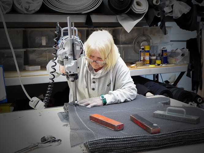 Evelyn cuts out garment sections using a band knife. It’s lethally sharp which is why she is wearing a chain mail glove.