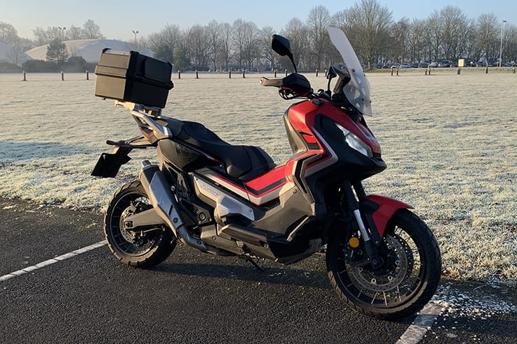 Honda’s 750cc, 75mpg adventure commuter scooter continues to defy convention. But we love it all the same