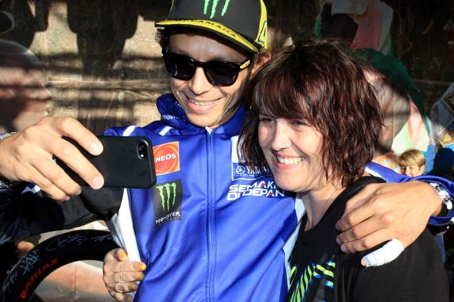 Valentino Rossi helps a fan to a selfie at the Day of Champions in August 2014