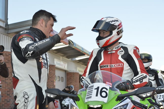 Rider Coach Chris Butcher demonstrates the 'Let's have a chat' signal used on track